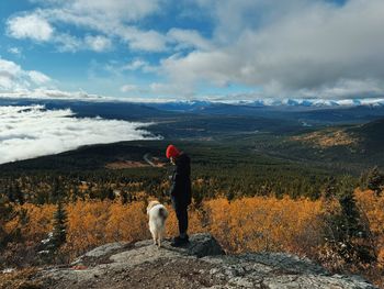 Rear view of woman walking on field against sky