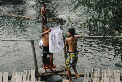 Rear view of men standing in water