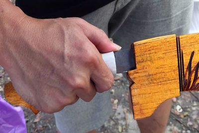 Close-up of man holding wood