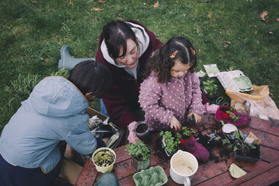 High angle view of family planting in old shoes at backyard