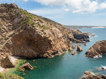 Scenic view of rocks on sea against sky