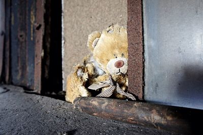 High angle view of abandoned teddy bear by wall