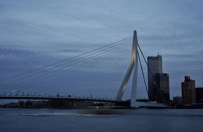 Suspension bridge over river against sky