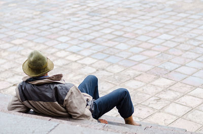 Rear view of people sitting on footpath