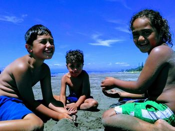 Happy friends enjoying in water against sky