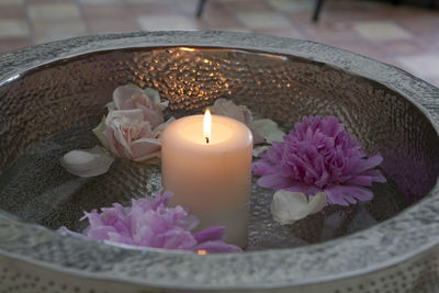 Close-up of candle with flowers in container