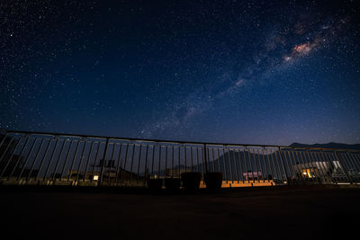 Illuminated bridge against sky at night