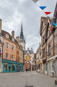 Buildings in city against cloudy sky