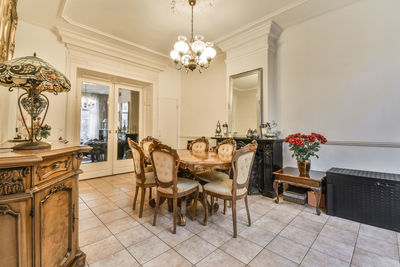 Empty chairs and tables and table and potted plant on floor at home