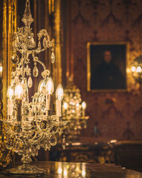 Close-up of illuminated crystal chandelier on table at home