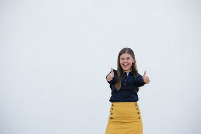 Portrait of smiling young woman against white background