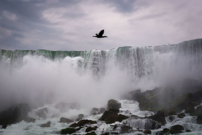 Scenic view of waterfall against sky