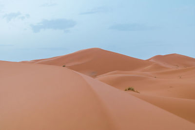 Sand dunes in desert against sky