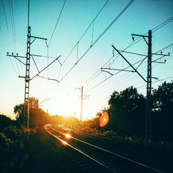 Railroad tracks against sky during sunset