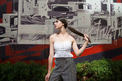 Woman standing against graffiti wall