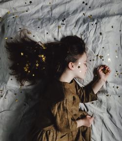 Directly above shot of girl sleeping on bed with star shape decorations at home