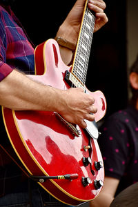 Midsection of man playing guitar