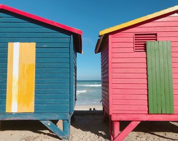 View of colourful beach hut against sky