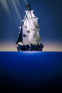 Sailboat in sea against blue sky