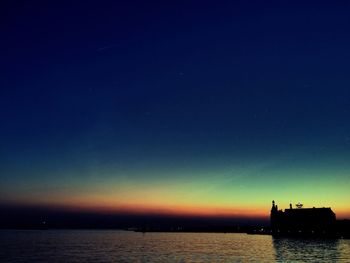 Boats in sea at sunset