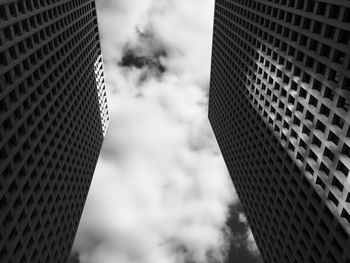 Low angle view of modern building against cloudy sky