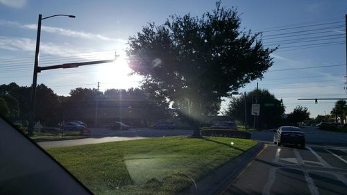 Cars on road against cloudy sky