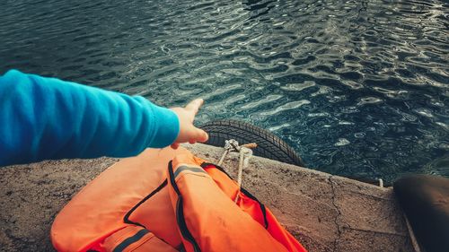 View of person pointing at rippled water