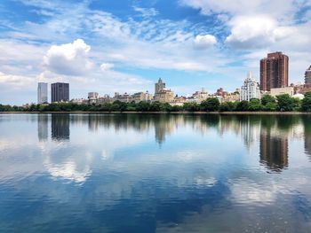 Reflection of buildings in city against sky