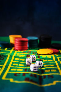 Close-up of gambling chips and dices on table at casino