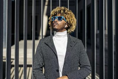 Portrait of young man standing against wall