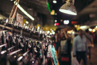 Close-up of clothes hanging on rack at street night market