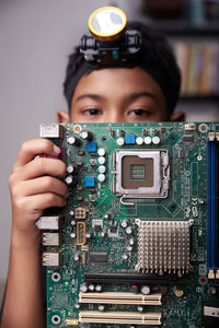 Portrait of man holding motherboard