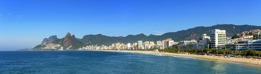 Panoramic image of ipanema beach in rio de janeiro with moutains in background