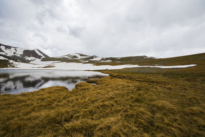 Alpine mountain lake landscape and view, snow and clouds in javakheti, georgia