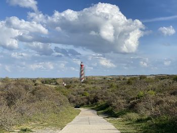 Footpath by lighthouse against sky