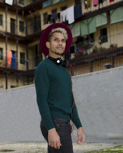 Young man with headphones and red hat in hand in the city