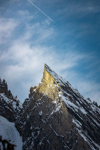 Low angle view of snow covered mountain against sky