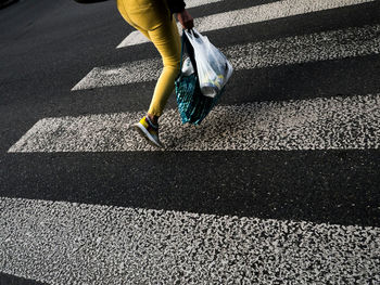 Low section of woman walking on zebra crossing