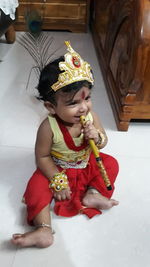 Girl looking away while sitting on floor at home