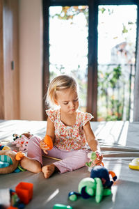 Portrait of cute girl playing with toys at home