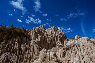 Low angle view of rocks against blue sky
