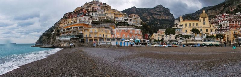 Panoramic view of buildings against cloudy sky