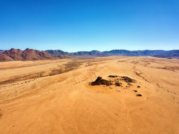 Scenic view of desert against clear blue sky