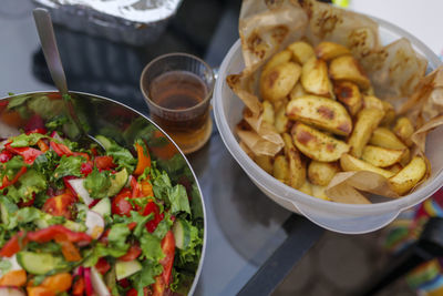 Selective focus. fresh cut spring vegetables mixed salad, slices of oven-cooked potatoes