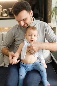 Father getting son dressed at home