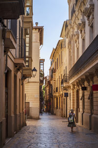 Rear view of woman walking in alley