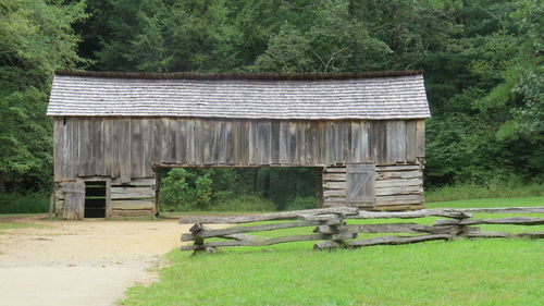 Old house on field against trees