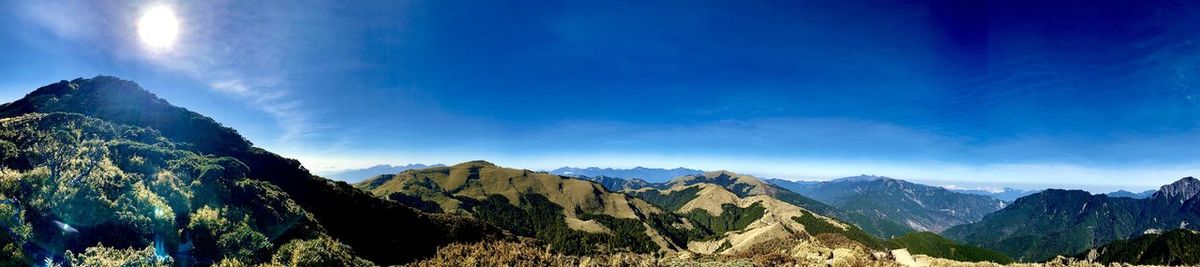 Panoramic view of mountains against blue sky