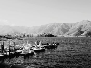 Boats moored in lake against sky