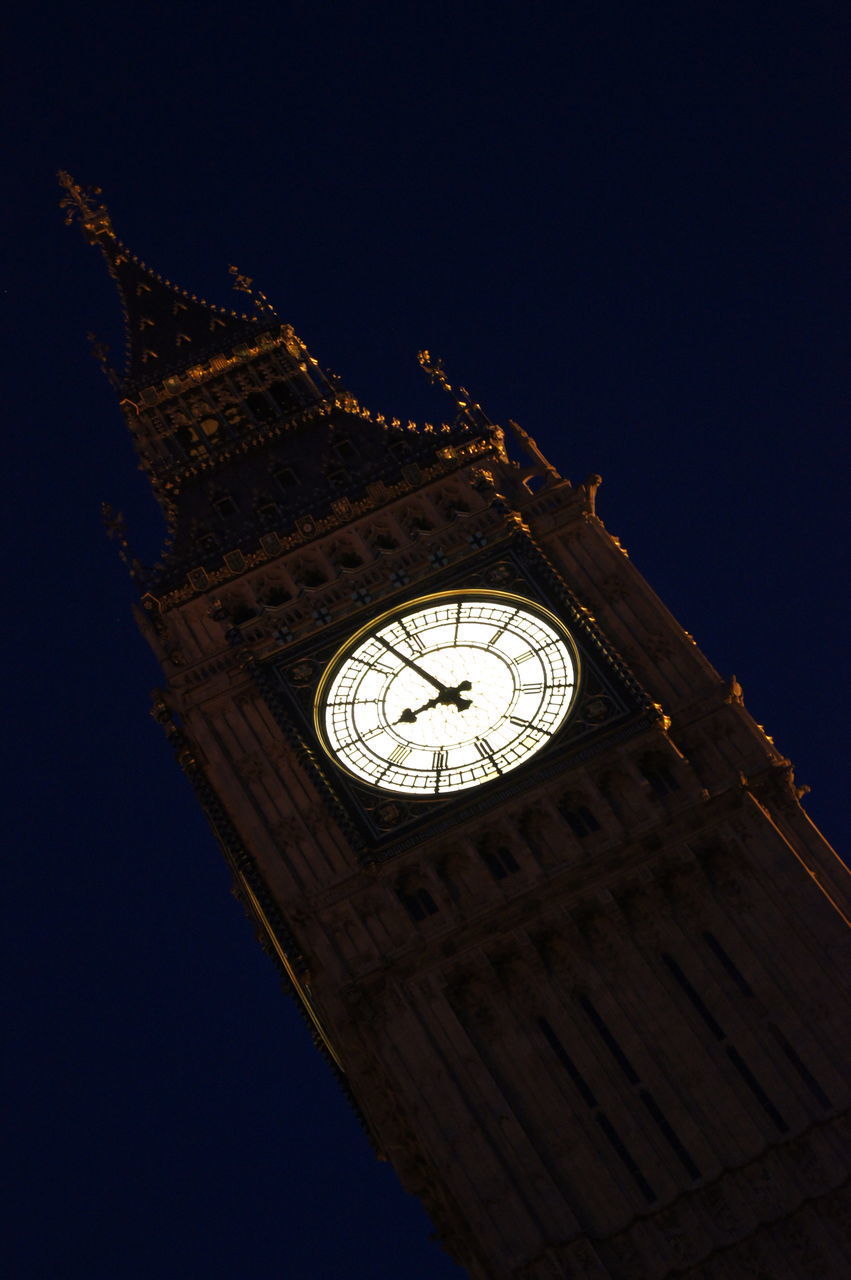 LOW ANGLE VIEW OF CLOCK TOWER IN CITY AGAINST SKY AT NIGHT